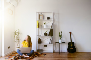 Woman in casual clothes sitting with a laptop