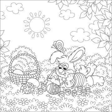 Happy little bunny painting and decorating Easter eggs with paints and a paintbrush on grass of a pretty forest glade on a sunny spring day, black and white vector cartoon illustration