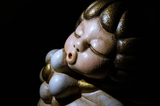 Macro photo of a putto with an o-shaped mouth