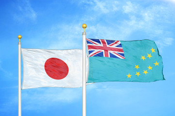 Japan and Tuvalu two flags on flagpoles and blue cloudy sky