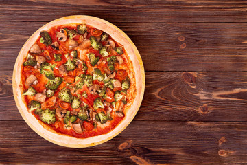Pizza with veggie vegetables on bamboo bottom, on wooden table top view, space for text