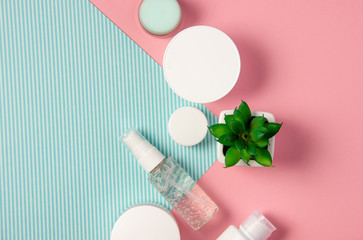 Obraz na płótnie Canvas Flat lay natural cosmetics. Cosmetic jars and bottles with cream, face mask, serum, peeling and lotion on a pink background. Organic cosmetics, home facial and body care