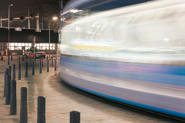 Close up fast blurred trail of train in traffic motion in illuminated metro, Netherlands.