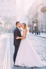 Naklejka premium the groom hugs and kisses the beautiful bride in a white dress.