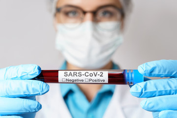 Female doctor is holding a blood sample of the SARS-CoV-2