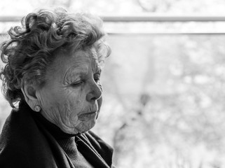 Elderly woman sitting by the window