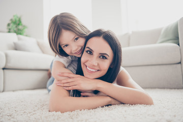 Close up photo of cute lovely candid mommy cuddle her kid girl lay carpet enjoy spend free time...