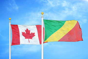 Canada and Congo  two flags on flagpoles and blue cloudy sky