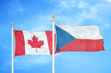 Canada and Czech Republic two flags on flagpoles and blue cloudy sky