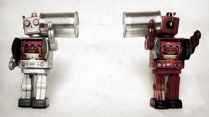 two retro robots on old tin can phones 