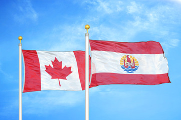 Canada and French Polynesia two flags on flagpoles and blue cloudy sky