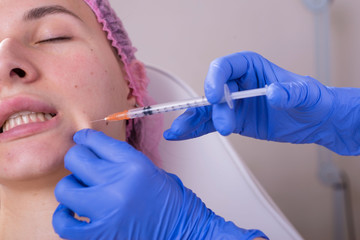 portrait in the cosmetologists office. A young girl in a medical suit, gloves and a syringe...