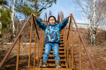 kid in the park on a metal staircase