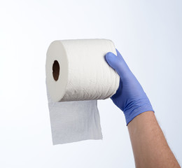 Right hand in blue glove holding a roll of toilet paper