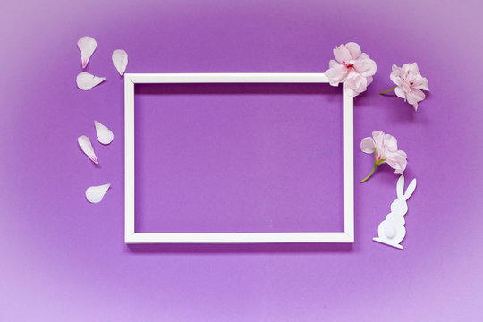 Delicate flowers  composition with blank frame for text on pastel pink background. Birthday, Easter, Mother's day, Happy Women's Day, Valentine's Day. Top view, copy space, flat lay.
