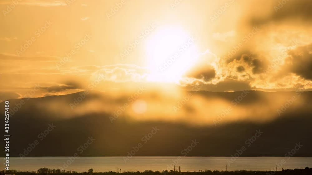 Canvas Prints time lapse of sun setting through glowing clouds over utah lake.