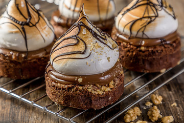 Portion of mini meringue cake with chocolate and nut