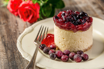 portion of red berry cake on plate on wood