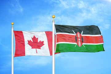 Canada and Kenya two flags on flagpoles and blue cloudy sky