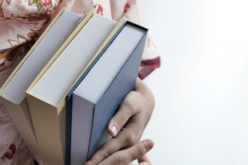 Young student holding books in her hands