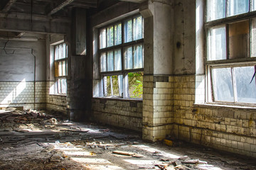 Large abandoned industrial hall. Dangerous area. Abandoned industrial interior with bright lights. Exclusion zone, radiation risk, lost city, apocalyptic building.