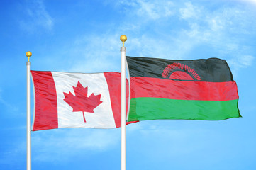 Canada and Malawi two flags on flagpoles and blue cloudy sky
