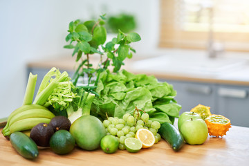 Fresh green fruit and vegetables on wooden counter