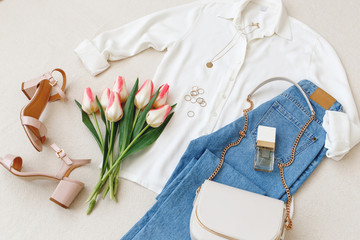 Blue jeans, white shirt, heeled sandals, small bag with chain strap, accessories, pink tulips...