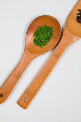 Wooden ladles with green herbs and food spices