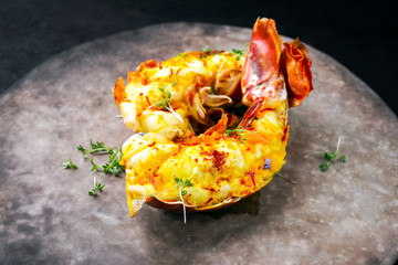 Traditionell gegrillte halbierte Langustenschwänze angeboten mit Safran Limetten Sauce als closeup...