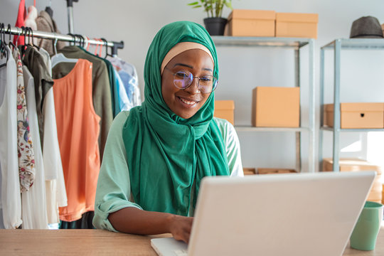 Muslim woman run a small business in her own home. Is the design and tailoring of clothes. Happy beautiful muslim business woman working about financial with business report 