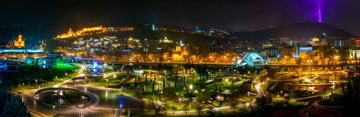 Fototapeta na wymiar Panoramic nightscape view of Tbilisi old town and Rike park. Romantic Gerogia and main tourist atrractions. Tbilisi. Sakartvelo.25.03.2020