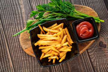 fries in black dish, greens and sauces