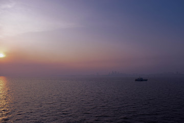 Sunset photograph shot from a cruise with a yacht against the Mumbai skyline.