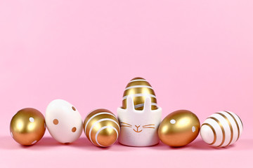 Elegant golden and white painted easter eggs with dots and stripes and cute easter egg cup in shape...