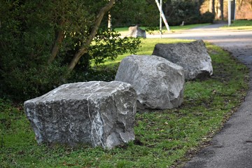 Decorative stones on green grass, in the park. 