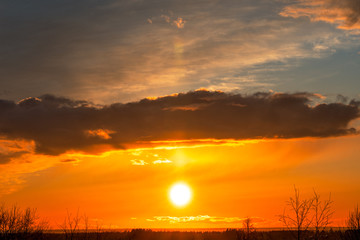 Beautiful colorful sunrise at the sea with dramatic clouds and sun shining. Dramatic sunset sky with orange colored clouds and sun