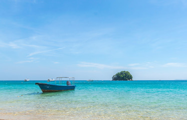 Floating boat in clear water at an island.