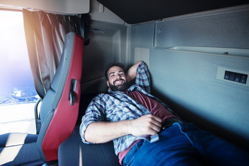 Truck driver enjoying comfortable cabin bed inside his truck.