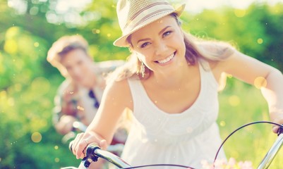 Happy young couple cycling through the park