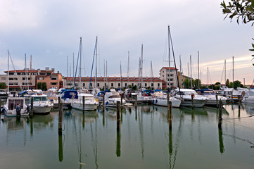 Fototapeta na wymiar Boats waiting in the port of Caorle, a charming holiday resort and fishing village.Italy.
