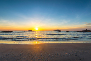 Obraz premium Beach wave with orange sunrise background