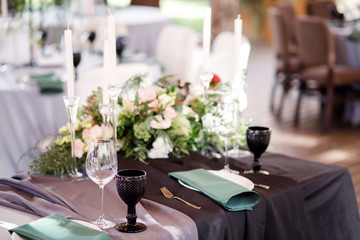 Festive wedding table setting with flowers, napkins, cutlery, glasses and candles, bright summer table decor. Wedding decor