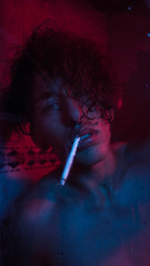  Portrait of man in the shower with a cigar and red and blue lights