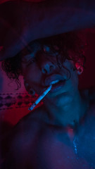  Portrait of man in the shower with a cigar and red and blue lights