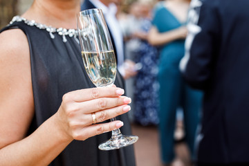 Young celebrating woman black dress .Woman holding a glass of champagne in celebration