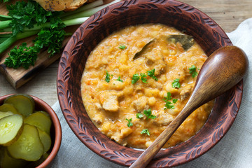 Bean and meat stew, served with pickles, bread and garlic. Rustic style.