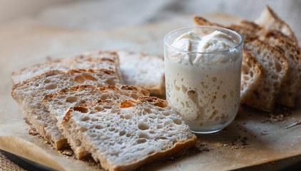 Slices of natural, homemade bread without yeast. .leaven in a glass. Starter. The concept of healthy eating and homemade food..