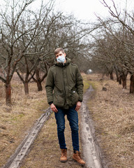 man in a medical mask stands on the street. respiratory virus protection 2019-nCoV, pandemic coronavirus flu, quarantine covid-19