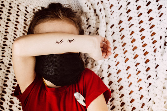 Child In A Medical Mask With A Thermometer